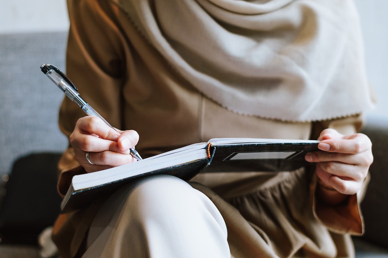 muslim woman writing notebook 7520627